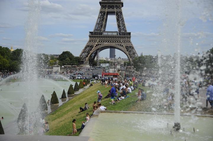 People in front the Eiffel Tower in Paris as temperatures degrees reach 41 Celsius.