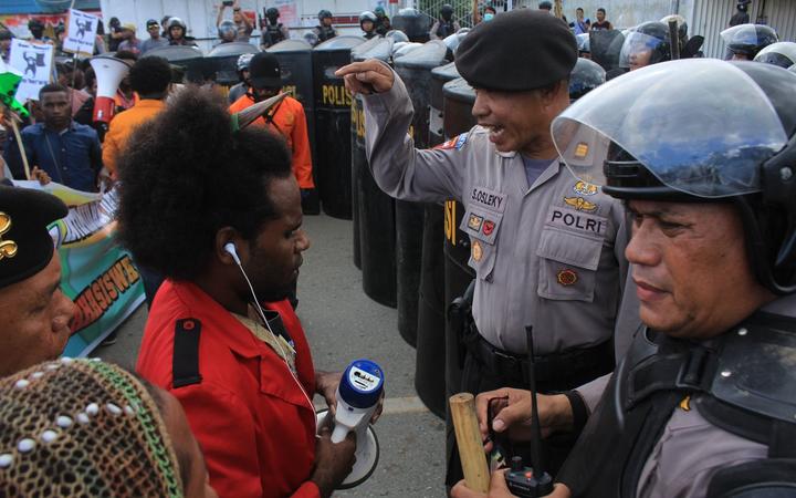 Indonesian police confront a protest leader in Jayapura.