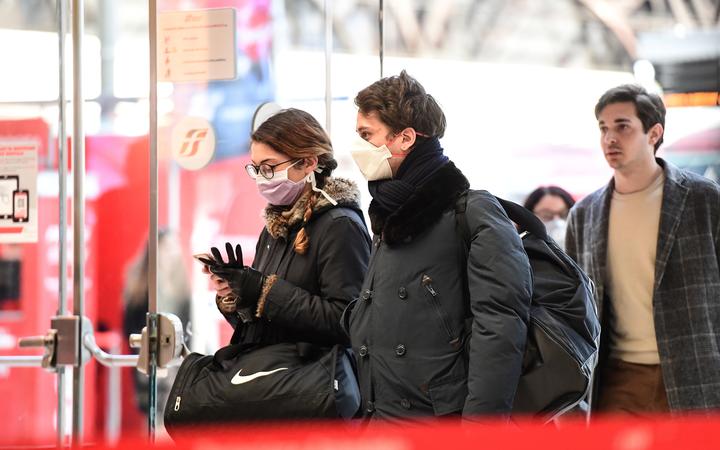 Passengers wearing protective face masks enter Milano Centrale railway station in Milan after millions of people were placed under forced quarantine in northern Italy. 