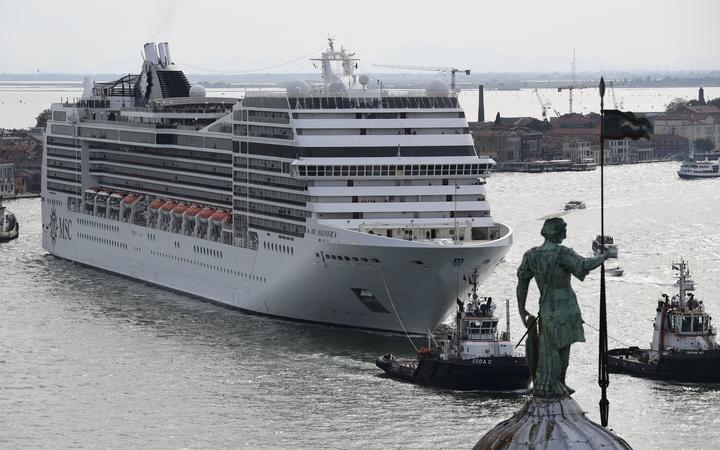 This picture taken on June 9, 2019 shows a MSC Magnifica cruise ship, seen from San Maggiore's bell tower, arriving in the Venice Lagoon carried by three tugboats. 