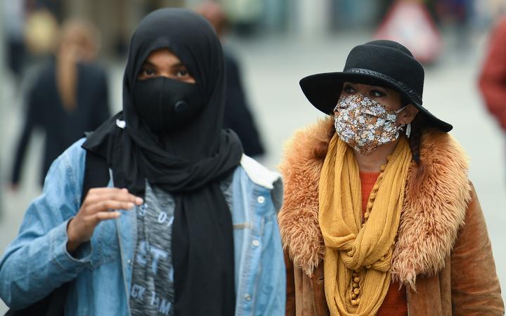 Women wear face masks or coverings due to the COVID-19 pandemic, as they walk in Liverpool, north west England on October 2, 2020, following the announcement of new local restrictions for certain areas in the northwest of the country, due to a resurgence of novel coronavirus cases. 