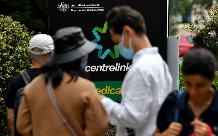 People wait in a queue to receive benefit payouts, including unemployment and small business support as the novel coronavirus inflicts a toll on the economy, at a Centerlink payment centre in downtown Sydney on 27 March 2020.