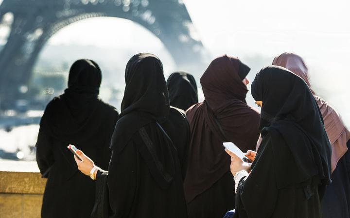 FRANCE. PARIS (75), 16TH ARR, VEILED WOMEN FRONT OF EIFFEL TOWER