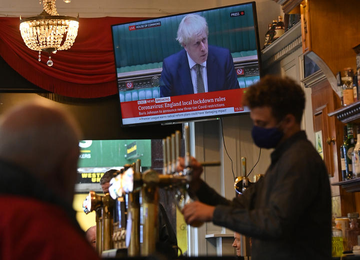 A television screens UK Prime Minister Boris Johnson speaking in the House of Commons, as customers sit at the bar of the Richmond Pub in Liverpool.