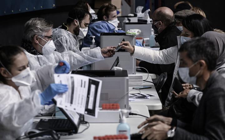 Health workers speak to people prior to being tested for Covid-19 in Lyon's sports arena ('Palais des Sports') which was turned into a giant testing centre, 12 October 2020.