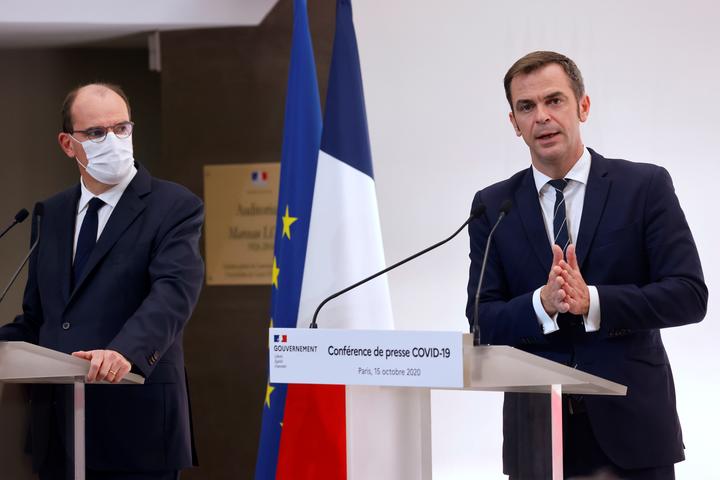 French Health Minister Olivier Veran (right) speaks flanked by French Prime Minister Jean Castex during a press conference on 15 October to present the details of new restrictions aimed at curbing the spread of the Covid-19 pandemic.