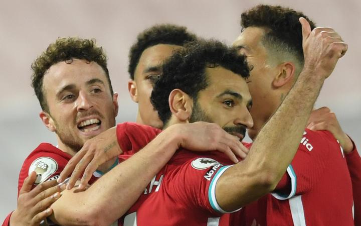 Liverpool's Portuguese striker Diogo Jota (L) celebrates scoring their second goal with Liverpool's Egyptian midfielder Mohamed Salah (R) and team-mates during the English Premier League football match against and Sheffield United at Anfield in Liverpool on October 24, 2020. 