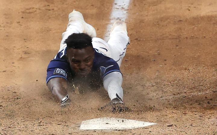 Randy Arozarena #56 of the Tampa Bay Rays slides into home plate during the ninth inning to score the game winning run to give his team the 8-7 victory against the Los Angeles Dodgers in Game Four of the 2020 MLB World Series.