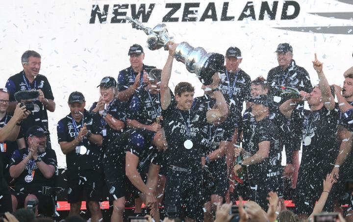 Team New Zealand's skipper Peter Burling (C) holds the America's Cup, affectionately known as the Auld Mug, after winning the 36th America's Cup against Luna Rossa Prada in Auckland on March 17, 2021. 