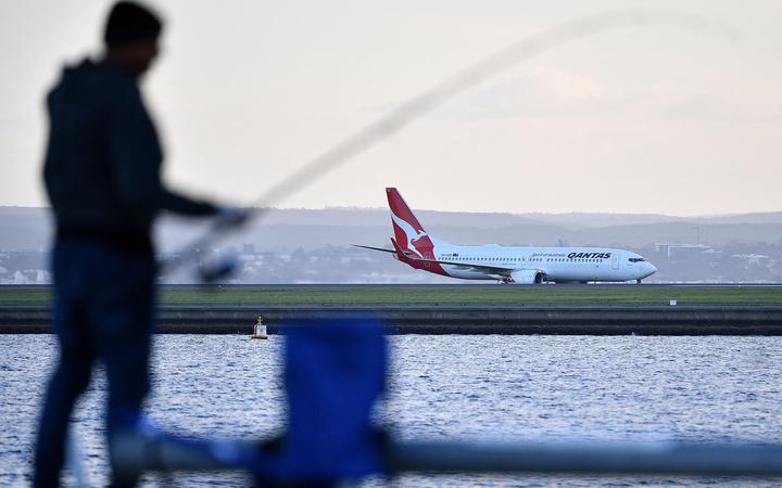 A Qantas Airline plane lands on Sydney International Airport in Sydney on March 27, 2020. 