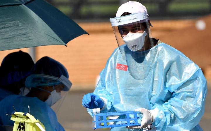 A health worker collects swab samples at a Covid-19 coronavirus drive through testing site in the Smithfield suburb of Sydney on August 12, 2021.