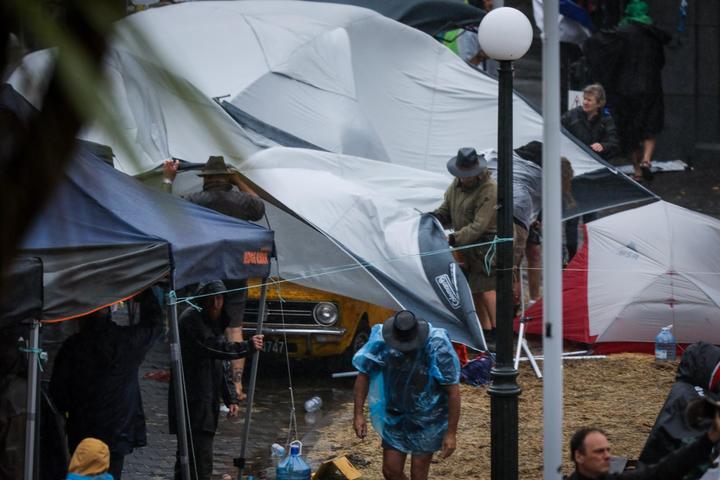 Protesters attempt to secure their tents outside Parliament on 13 February, 2022.