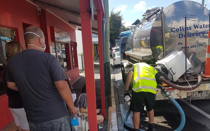 People filling up from a water tanker in the main street of the Wellington surburb of Brooklyn.