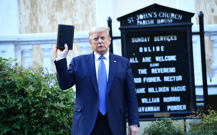 US President Donald Trump holds up a bible in front of St John's Episcopal church.