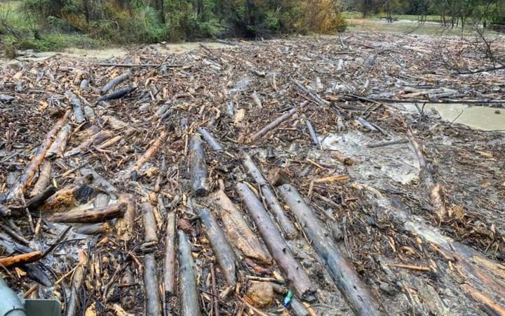 Contractors work to clear logs from as river along Paroa Rd north of Tolaga Bay.