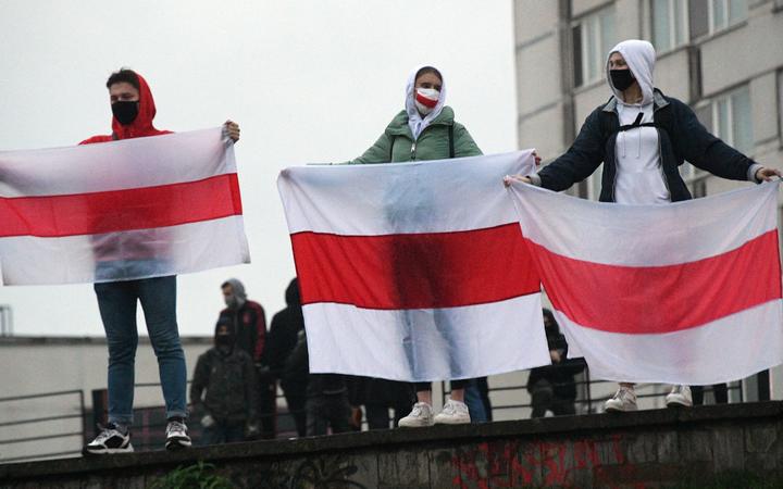 Protesters hold historical white-red-white flags of Belarus during a rally, in Minsk, Belarus.