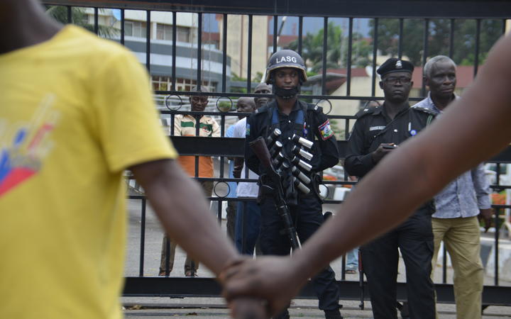 People hold hands to barricade the protesters from the Nigerian Police force as they march at Alausa Secretariat in Ikeja, Lagos State.