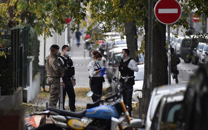 Security and emergency personnel are on October 31, 2020 in Lyon at the scene where an attacker armed with a sawn-off shotgun wounded an Orthodox priest in a shooting before fleeing, said a police source. 