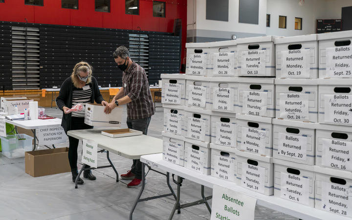 Poll workers check in a box of absentee ballots in Sun Prairie, Wisconsin, on 3 November 2020. 