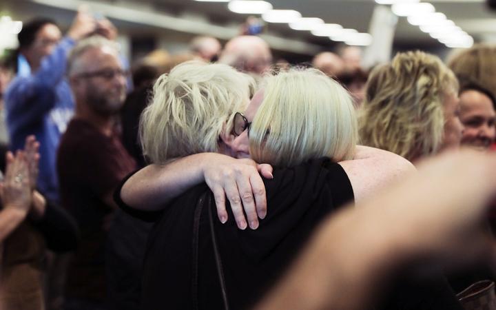 A passenger is reunited with loved ones after the first quarantine-free Wellington flight from Auckland disembarks.