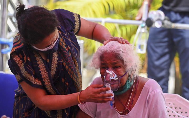 A Covid-19 patient breathes with the help of oxygen provided by a Gurdwara, a place of worship for Sikhs, under a tent installed along a roadside in Ghaziabad on 28 April 2021. 