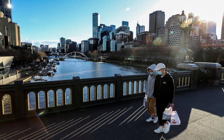Pedestrians wearing face masks walk through Melbourne's Southbank on 16 July 2021, following a fresh Covid-19 lockdown.