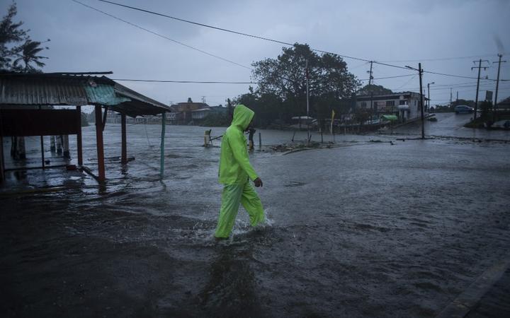 Un hombre camina por una calle inundada por las lluvias torrenciales provocadas por el huracán Grace en Teculutla, Veracruz, México, el 21 de agosto de 2021. 