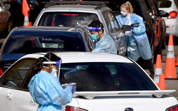 Medical personnel take details at a drive-through Covid-19 testing station in Melbourne on August 19, 2021, as Australia battles an outbreak of the Delta variant of coronavirus.