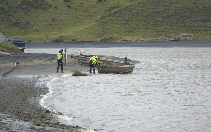 Locals and Landsar personnel at Kiritehere Beach where Thomas Phillips' car was found.