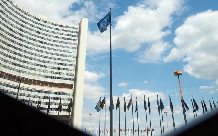 The flag of the International Atomic Energy Agency (IAEA) flutters in front of the IAEA building in Vienna on July 10, 2019. 