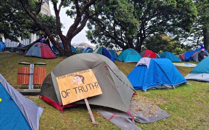 A sign leans against a tent at the protest camp at Parliament. 