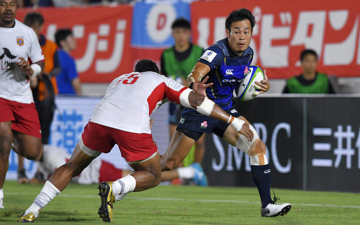 Japan's Kenki Fukuoka runs past David Halaifonua of Tonga to score