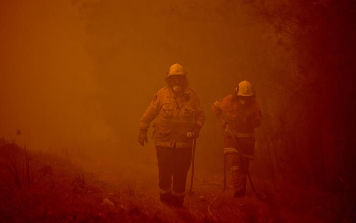 Firefighters tackle a bushfire in the town of Moruya, south of Batemans Bay, in New South Wales.