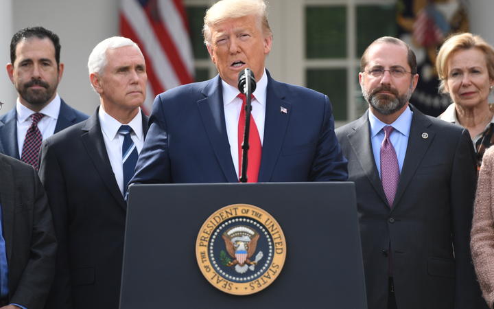 Surrounded by members of the White House Coronavirus Task Force, US President Donald Trump speaks at a press conference on COVID-19.