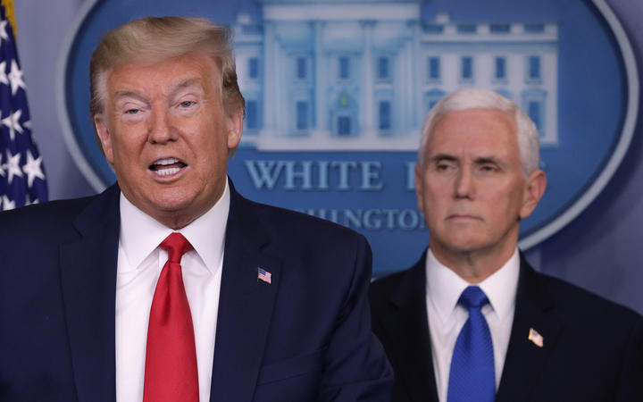 President Donald Trump is flanked by Vice President Mike Pence while speaking during a news briefing on the latest development of the coronavirus outbreak in the US at the White House on 18 March. 