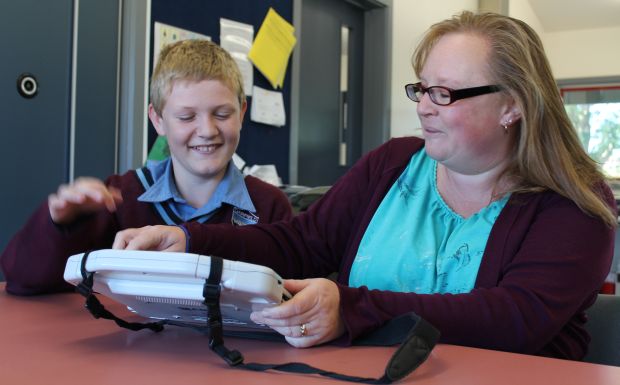 Nathan Carter works on the ipad with his teacher aide Sam Newbigging