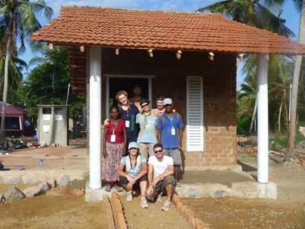 Building October Completed house with volunteer team and grateful owners Mary right and Sheldon left Copyright Iain Pearson small